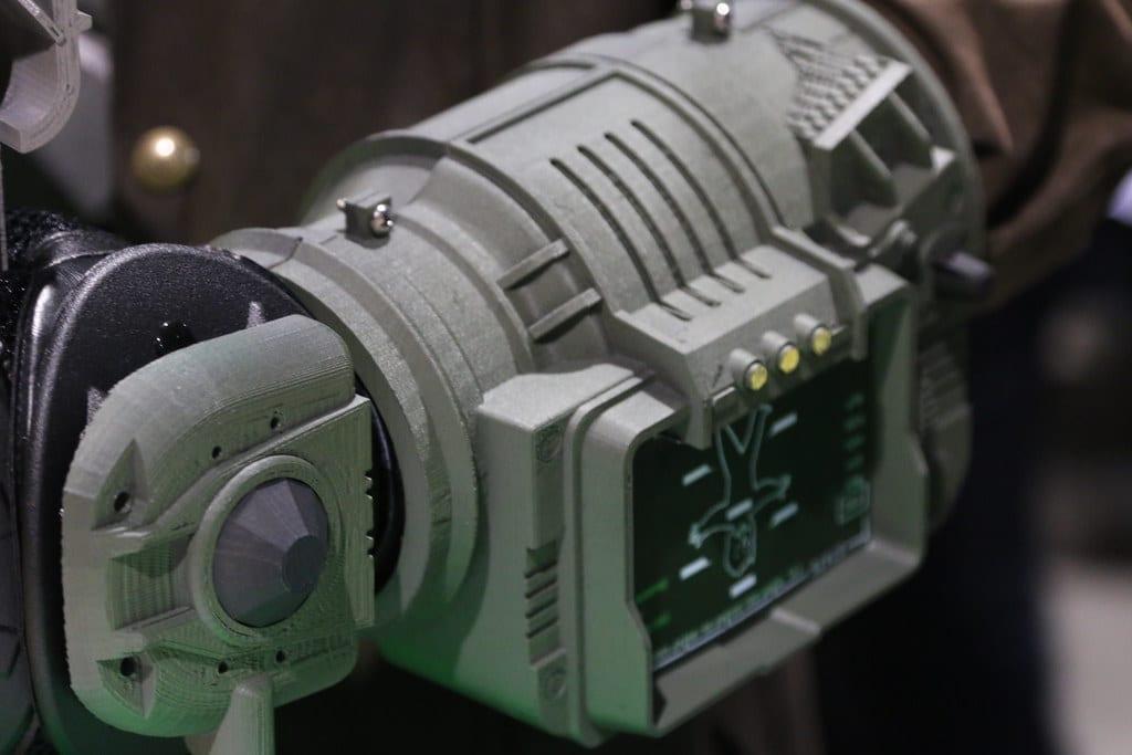 Close-up of a 3D printed forearm prop with a screen detail, showing visible print layer lines across the curved surfaces