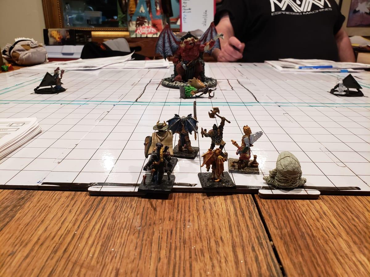 Painted miniatures standing on a one inch grid board during a Dungeons and Dragons game