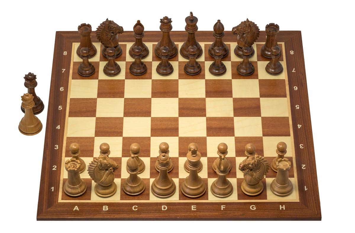 A Staunton pattern chess set set up on a board