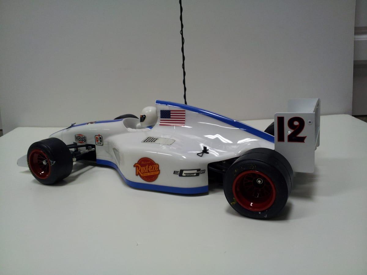 Built 1/10 scale radio-controlled Formula 1 car with a white and blue body shell and red wheels