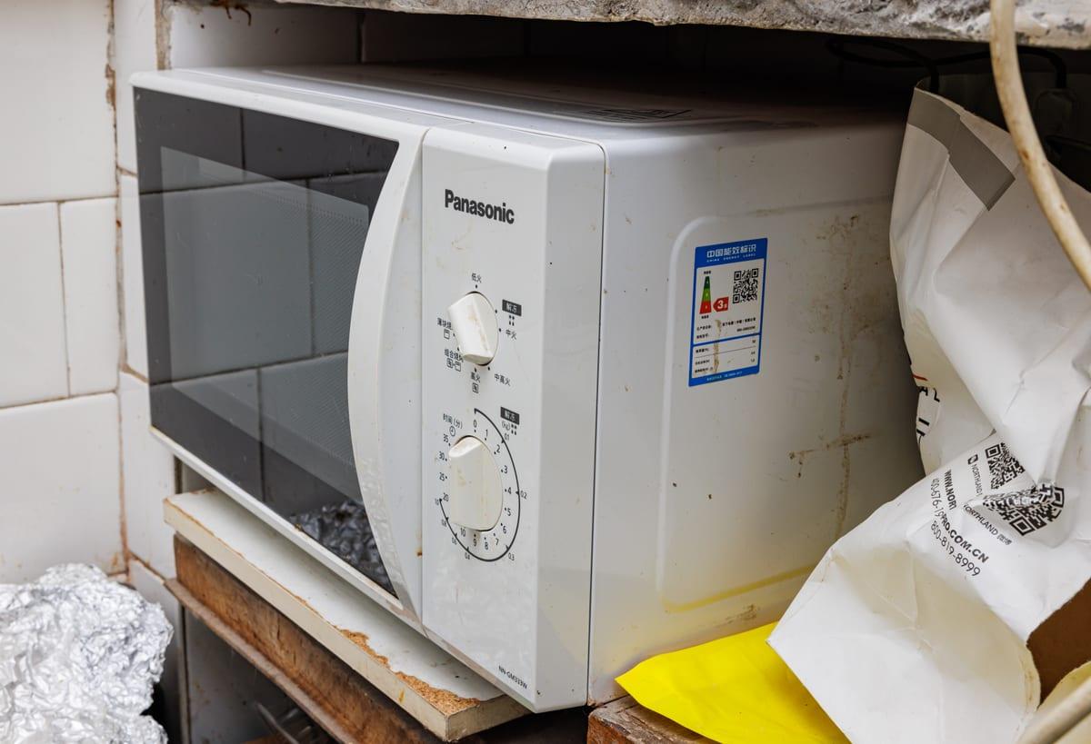 White countertop microwave oven with a moulded grip formed into the edge of its door