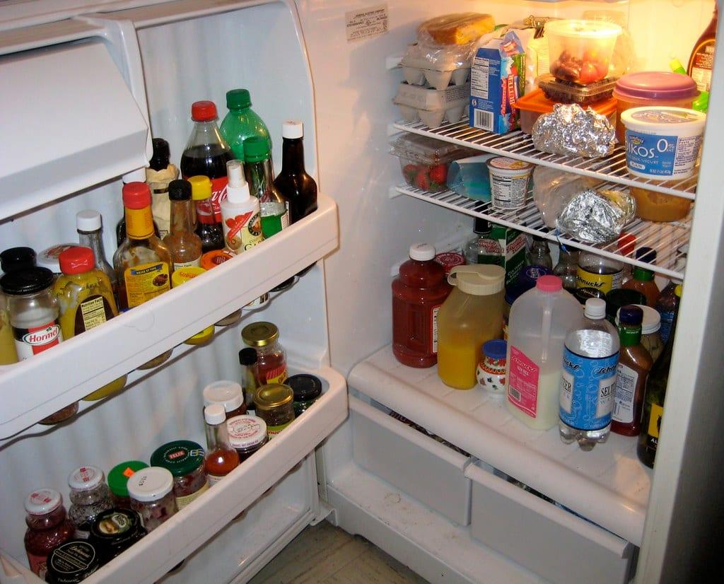 Open refrigerator with loaded wire shelves and moulded plastic door bins