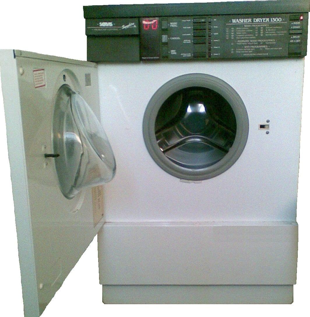 An older white front-loading washer dryer with the door open, showing a dark control fascia mounted along the top edge